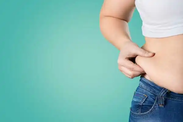 Image of woman pinching her love handles to show weight gain Leighton Buzzard